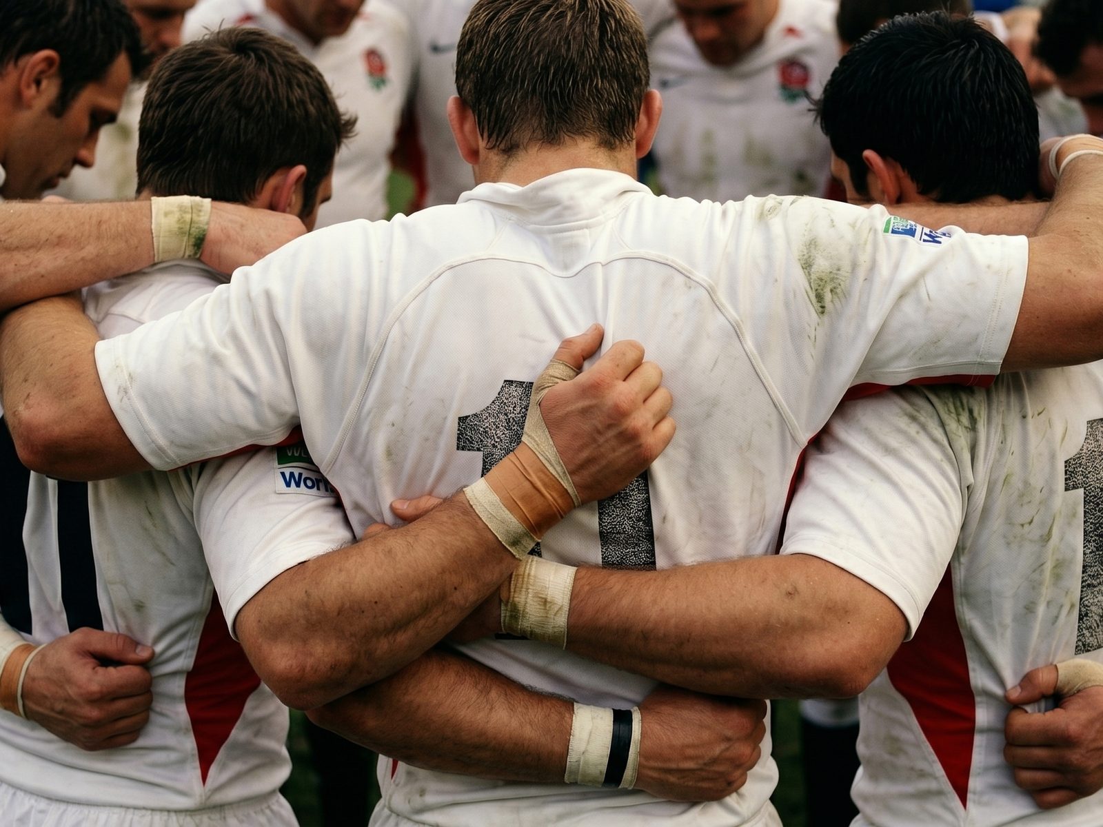 Squadra di rugby unita in cerchio a centrocampo prima della partita